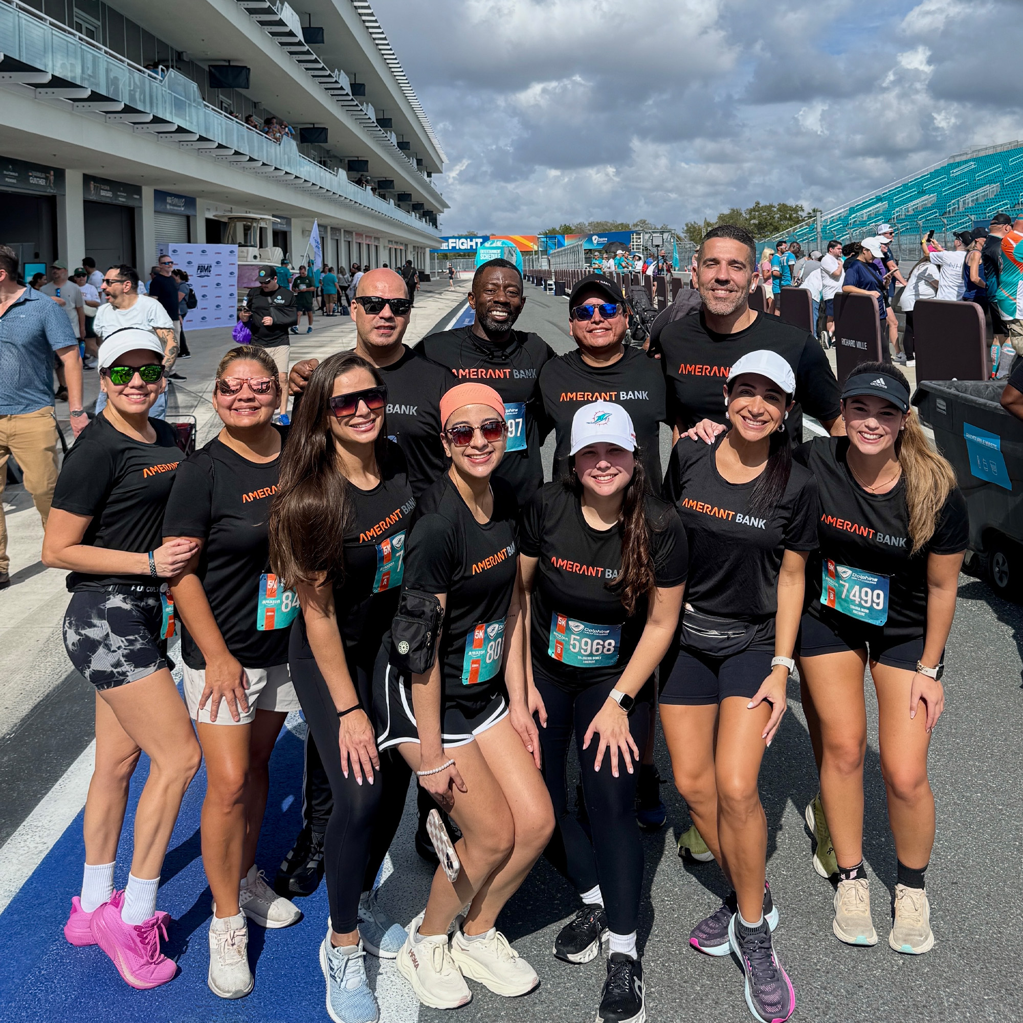 amerant bank team members pose on the track during dolphins cancer challenge 2026