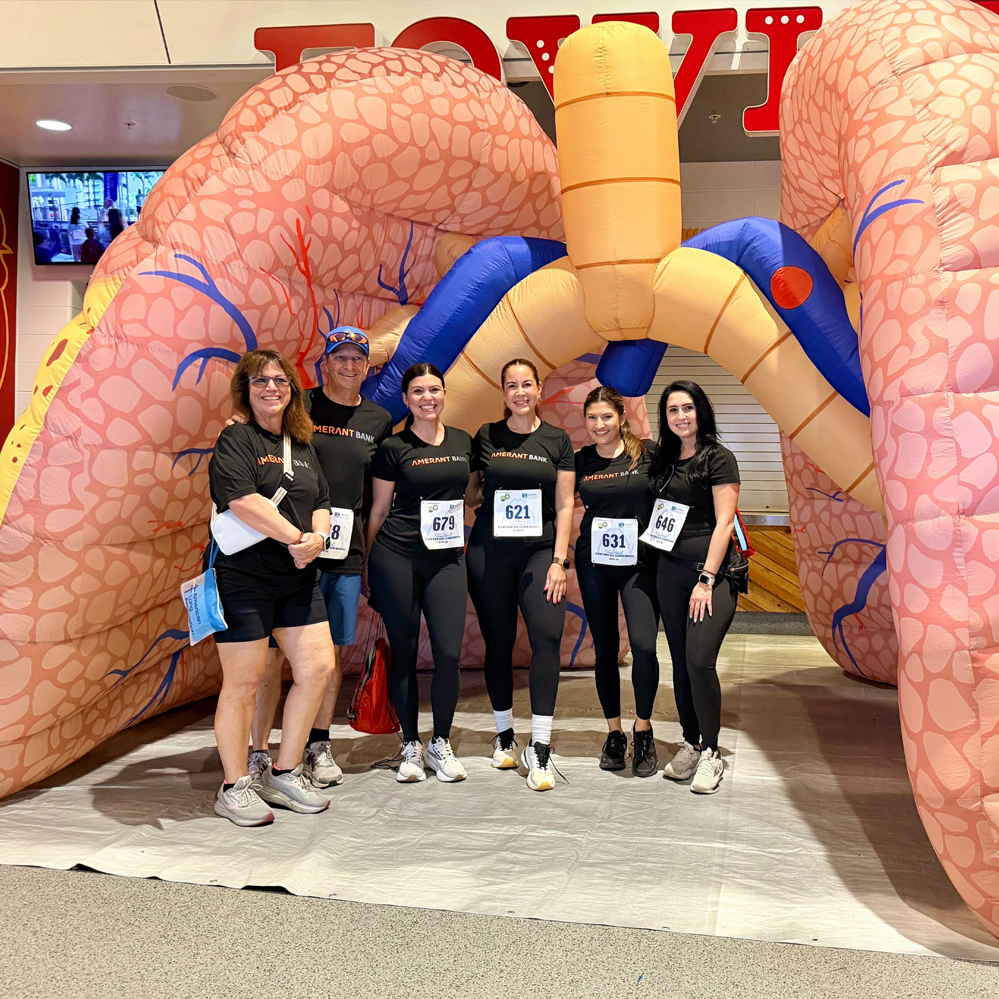 amerant team members pose in front of inflated lungs at the fight for air climb 2026