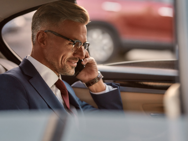 Professional speaking on a mobile phone while traveling in a vehicle.