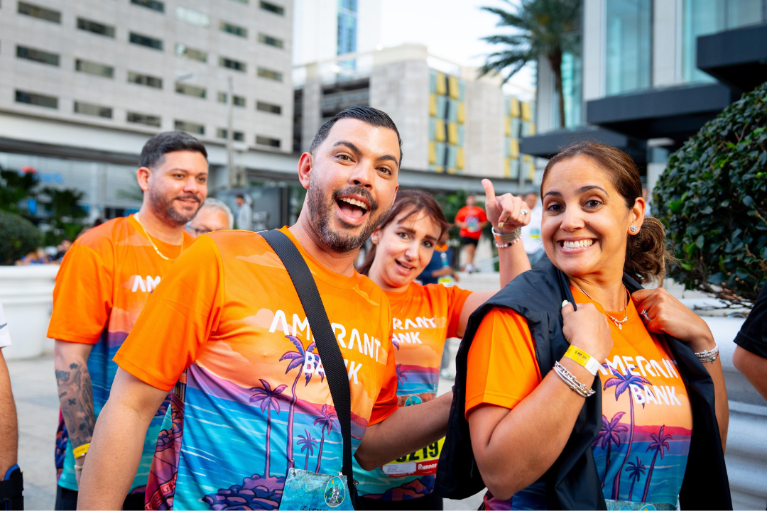 Amerant Bank team members wearing event shirts and participating in a community 5K race in an outdoor setting.